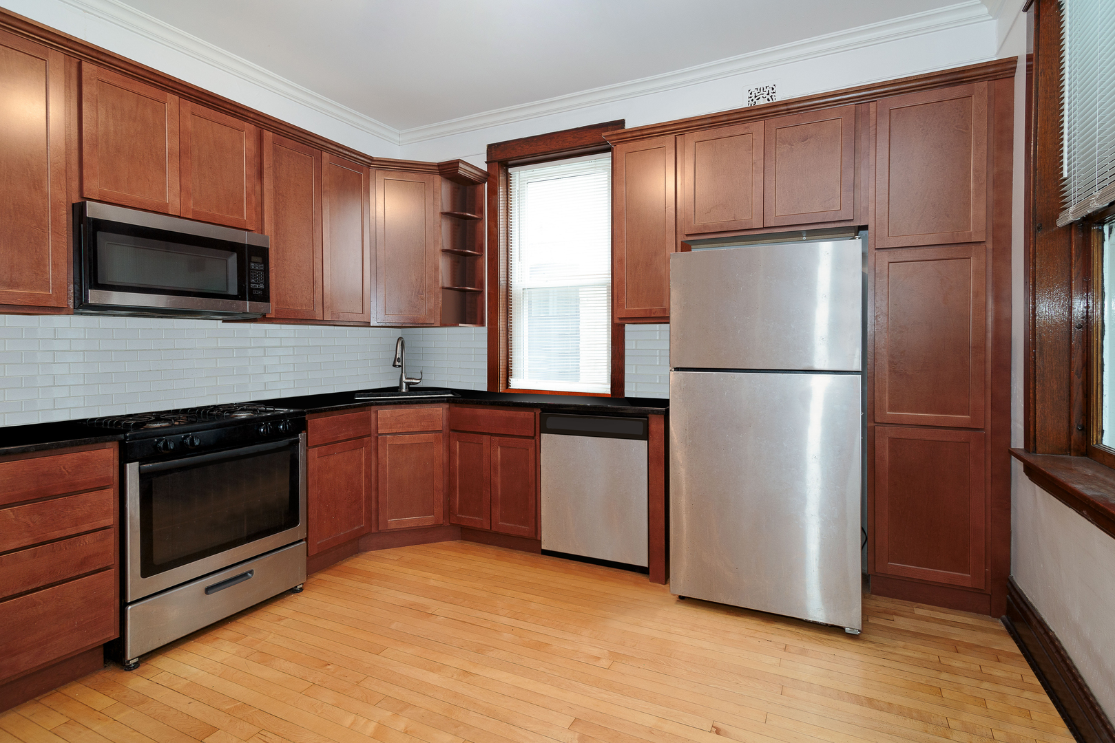 2347 West Walton Street, Unit 2 Chicago, IL 60622 - Photo 2 of 11 a kitchen with granite countertop stainless steel appliances a refrigerator a microwave a sink and cabinets
