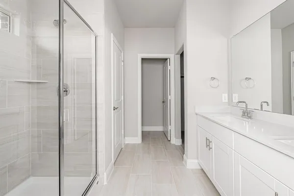 a spacious bathroom with a granite countertop sink a mirror and a shower
