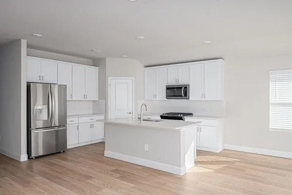 a kitchen with stainless steel appliances a refrigerator sink and microwave