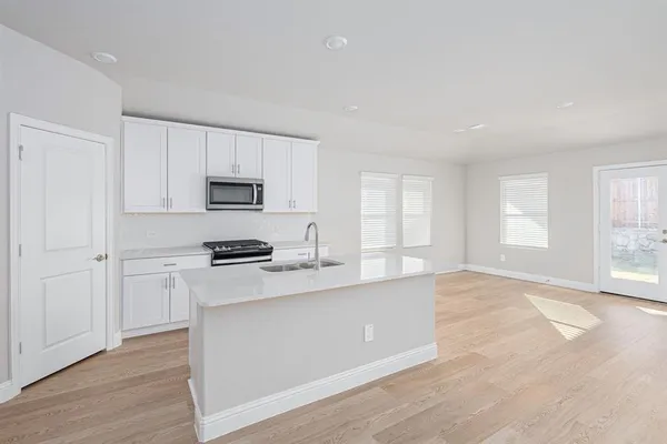 a kitchen with granite countertop white cabinets and stainless steel appliances