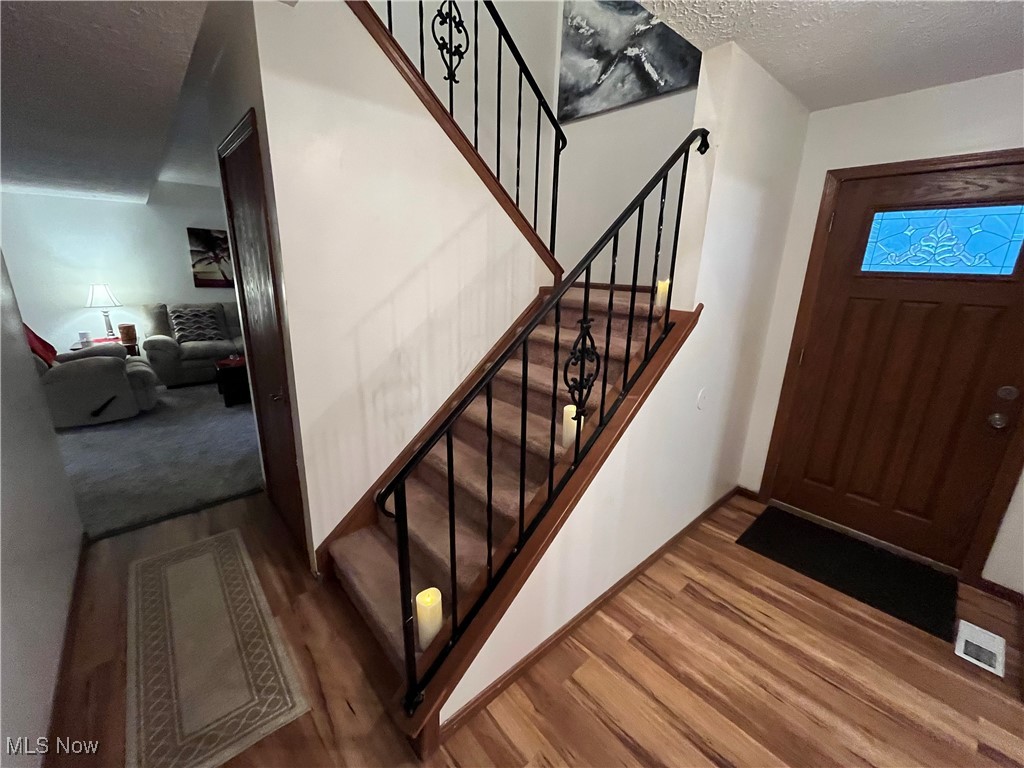 1455 Welch Road Painesville, OH 44077 - Photo 20 of 42 Foyer with a textured ceiling, stairway, and wood finished floors