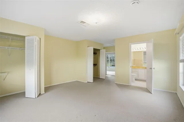 an empty room with closet and a bathroom view