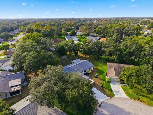 an aerial view of a house with a garden and lake view