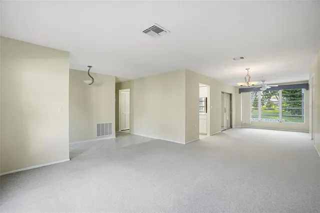 a view of empty room with windows and ceiling fan