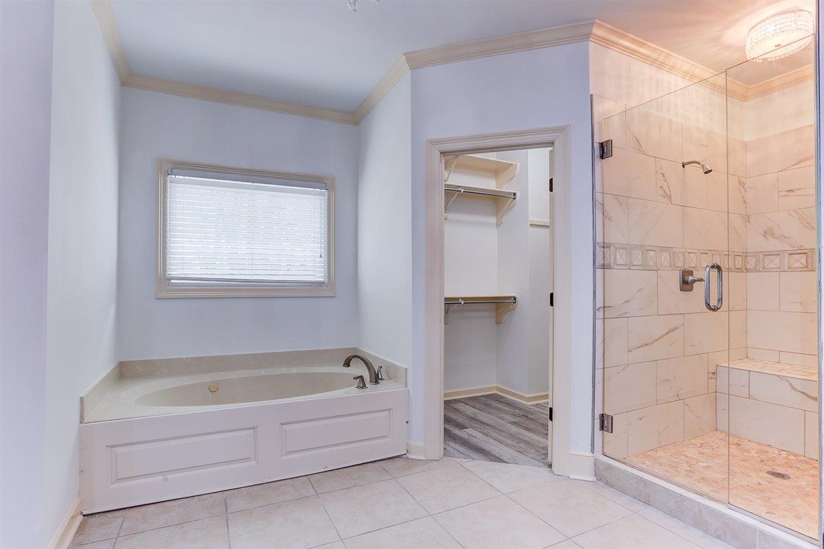 608 Roxburgh Drive Collierville, TN 38017 - Photo 32 of 40 Bathroom with crown molding, a spacious closet, a shower stall, a bath, and light tile patterned floors