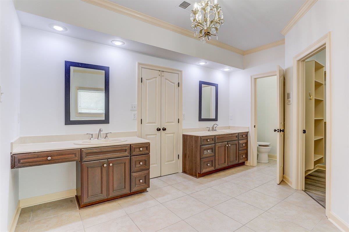 608 Roxburgh Drive Collierville, TN 38017 - Photo 34 of 40 Bathroom with two vanities, light tile patterned flooring, crown molding, a chandelier, and a walk in closet