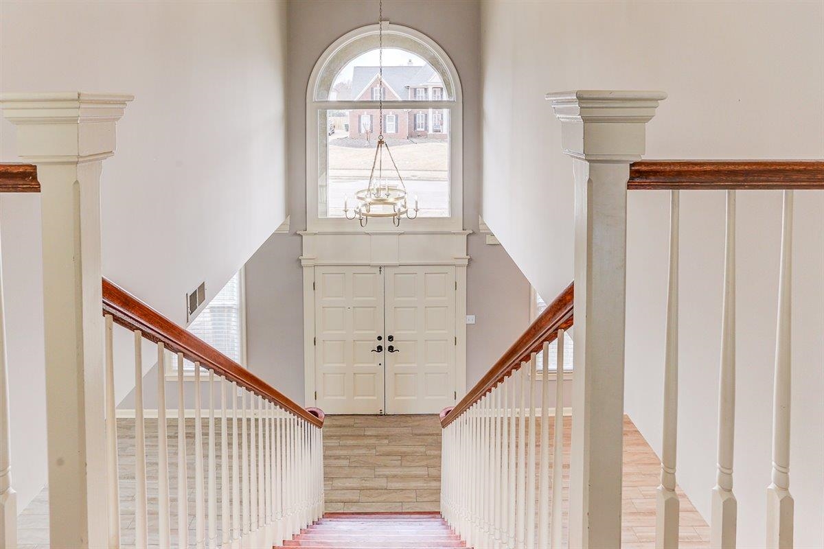 608 Roxburgh Drive Collierville, TN 38017 - Photo 37 of 40 Foyer entrance featuring a towering ceiling, wood finished floors, stairs, and a chandelier