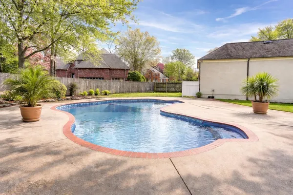 a front view of a house with garden and trees