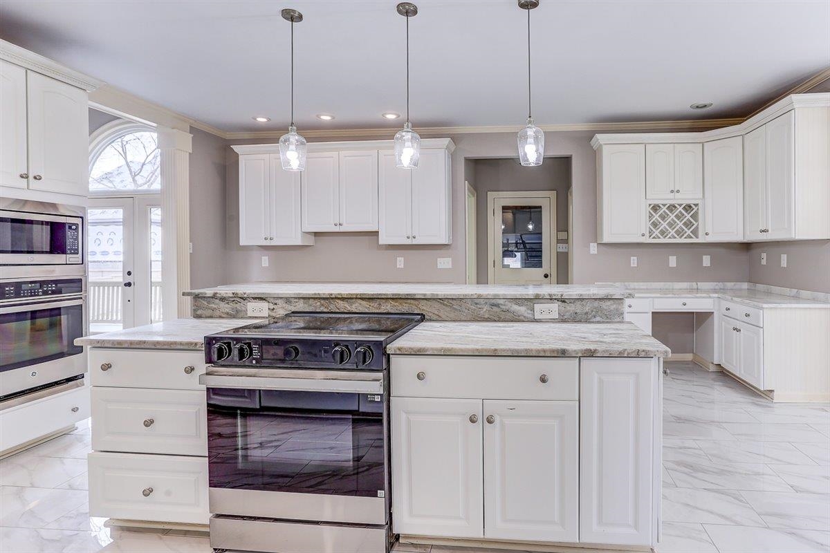 608 Roxburgh Drive Collierville, TN 38017 - Photo 9 of 40 Kitchen with light marble finish floors, stainless steel appliances, white cabinetry, ornamental molding, and recessed lighting