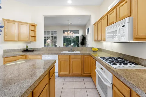 a kitchen with stainless steel appliances granite countertop a sink and a refrigerator