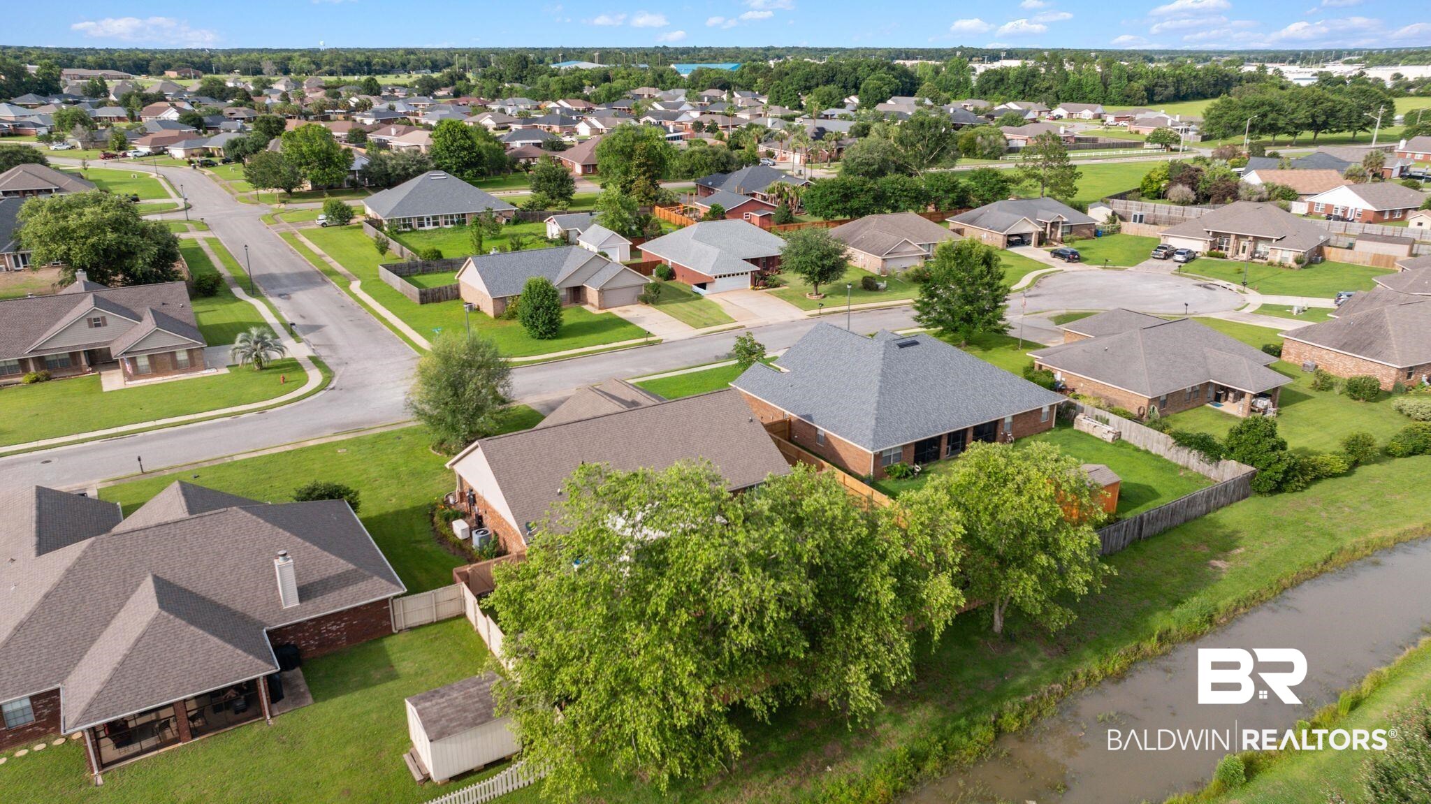 562 Vestige Mews Foley, AL 36535 - Photo 51 of 54 Suburban neighborhood featuring varied residential architecture, mature landscaping, and an adjacent canal