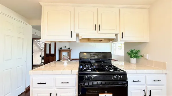 a kitchen with a stove and white cabinets
