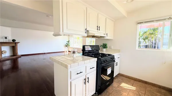 a kitchen with a stove and a white wooden cabinets