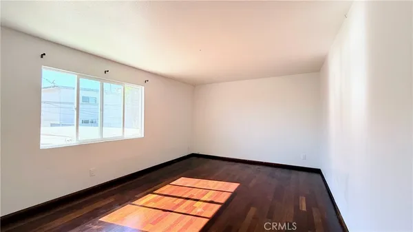 a view of a room with wooden floor and small window