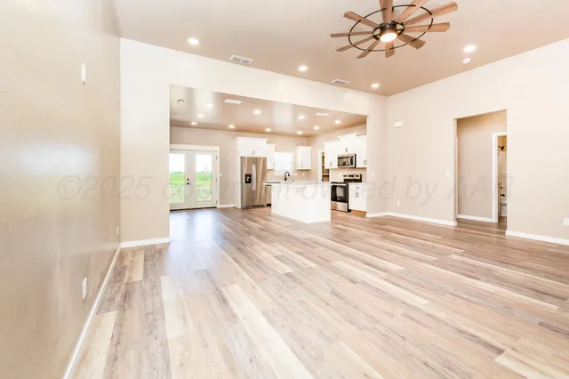 a spacious bedroom with a bed and a chandelier