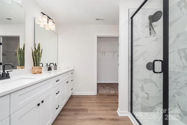 a bathroom with a double vanity sink mirror and shower