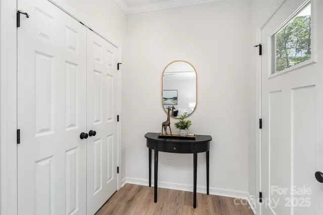 a view of a livingroom with wooden floor table and entryway