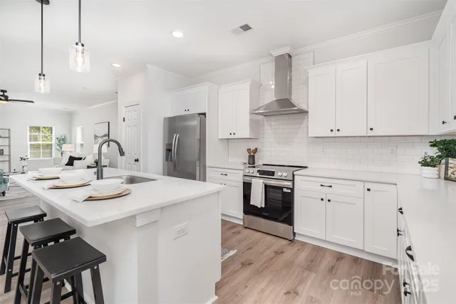 a kitchen with stainless steel appliances kitchen island a sink stove and refrigerator