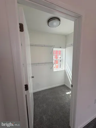 a view of an empty room and chandelier fan