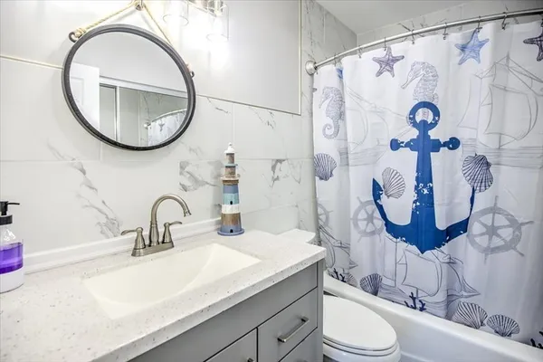 a bathroom with a sink a mirror a toilet and a mirror