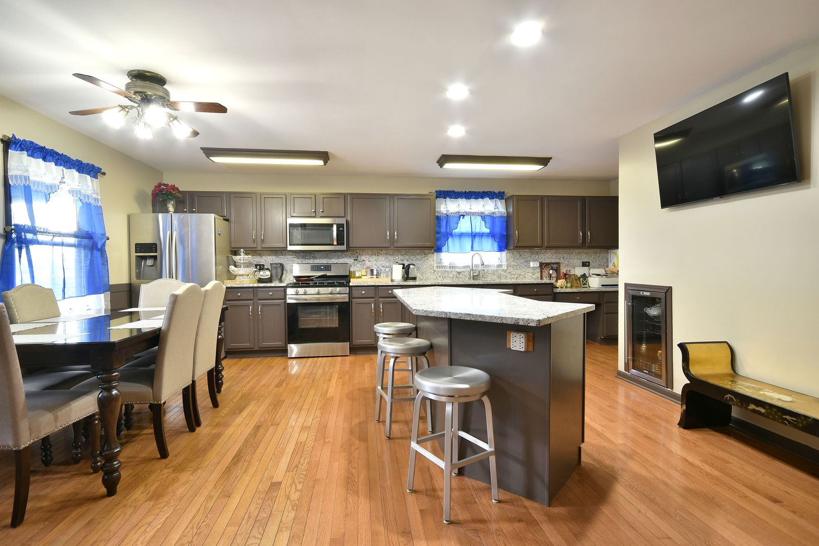 9N590 Flora Drive Elgin, IL 60123 - Photo 5 of 31 a kitchen with stainless steel appliances granite countertop a stove top oven a sink a dining table and chairs with wooden floor