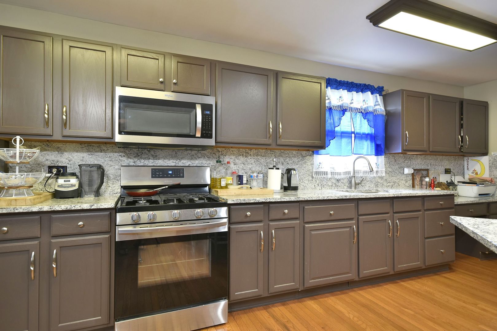 9N590 Flora Drive Elgin, IL 60123 - Photo 7 of 31 a kitchen with kitchen island granite countertop a sink cabinets and stainless steel appliances