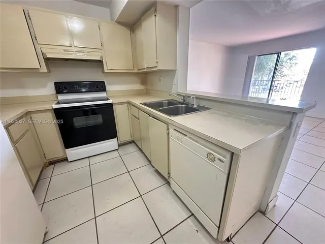 a kitchen with granite countertop a stove sink and cabinets