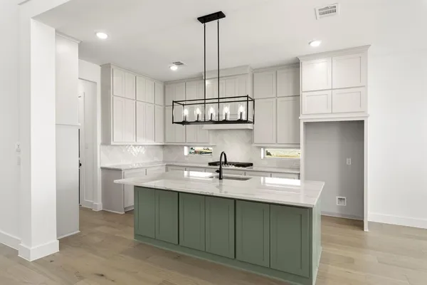 a kitchen with stainless steel appliances granite countertop a sink a stove and a refrigerator