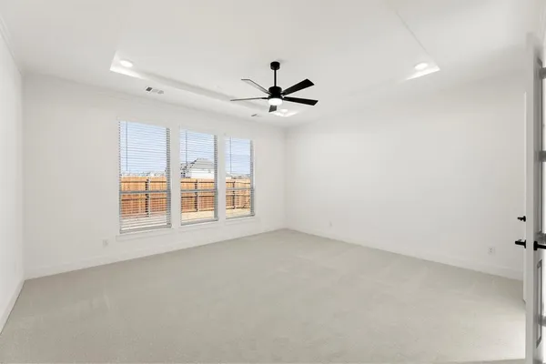 an empty room with a window and a ceiling fan