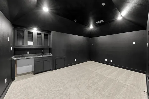 a large kitchen that has a lot of cabinets a sink and a stove top oven