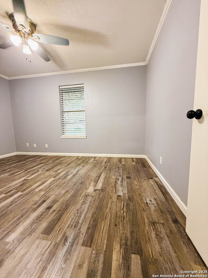 1403 West Hefferman Street Beeville, TX 78102 - Photo 13 of 15 a view of a room with wooden floor and a ceiling fan