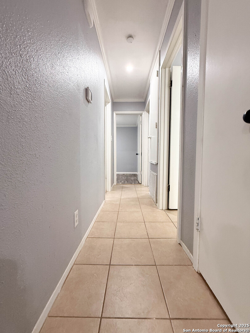 1403 West Hefferman Street Beeville, TX 78102 - Photo 10 of 15 a view of a hallway with wooden floor and a bathroom
