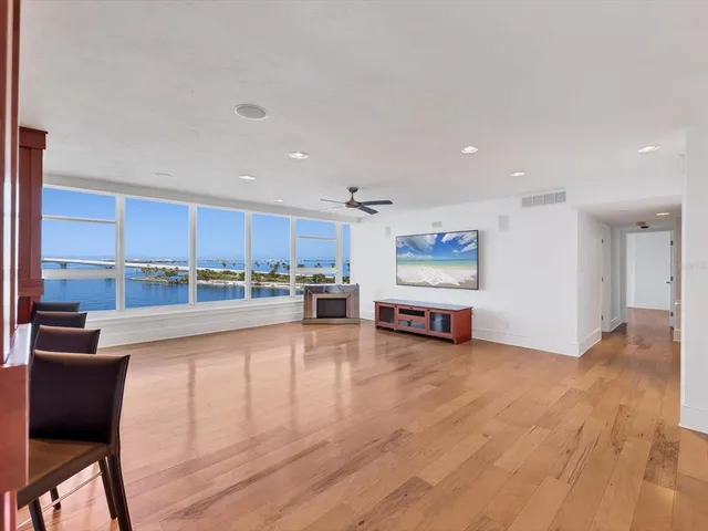 a living room with stainless steel appliances furniture a rug and a kitchen view