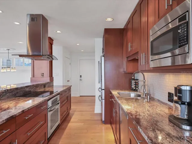 a kitchen with stainless steel appliances granite countertop a sink stove and cabinets