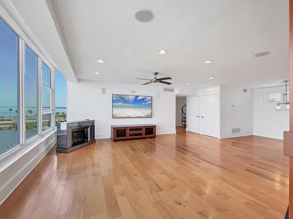 226 Golden Gate Point, Unit 63 Sarasota, FL 34236 - Photo 25 of 48 an empty room with wooden floor and windows