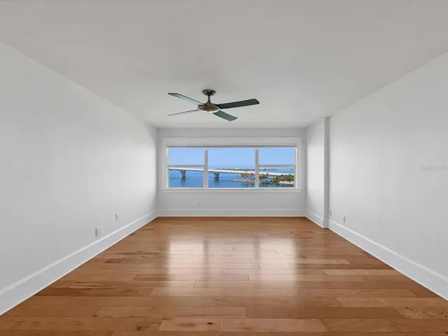 a view of a livingroom with wooden floor and a ceiling fan