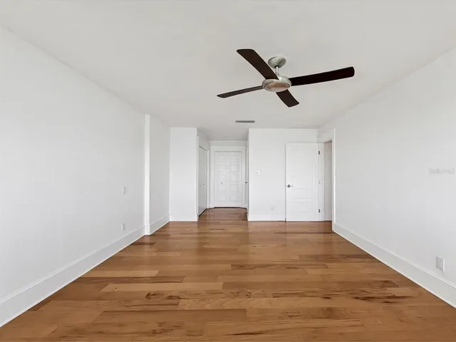 a view of empty room with wooden floor