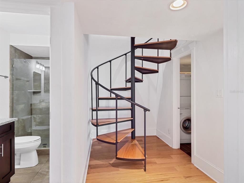 226 Golden Gate Point, Unit 63 Sarasota, FL 34236 - Photo 31 of 48 a view of a hallway with wooden floor and a bathroom