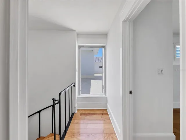a view of a hallway with wooden floor and staircase