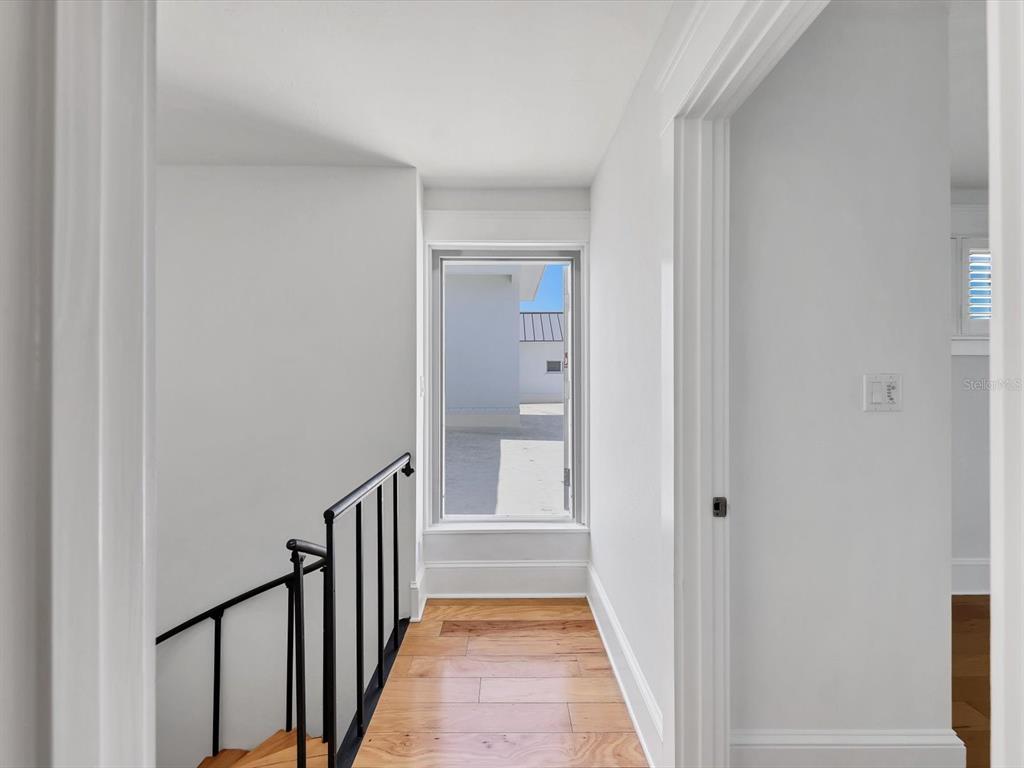 226 Golden Gate Point, Unit 63 Sarasota, FL 34236 - Photo 38 of 48 a view of a hallway with wooden floor and staircase