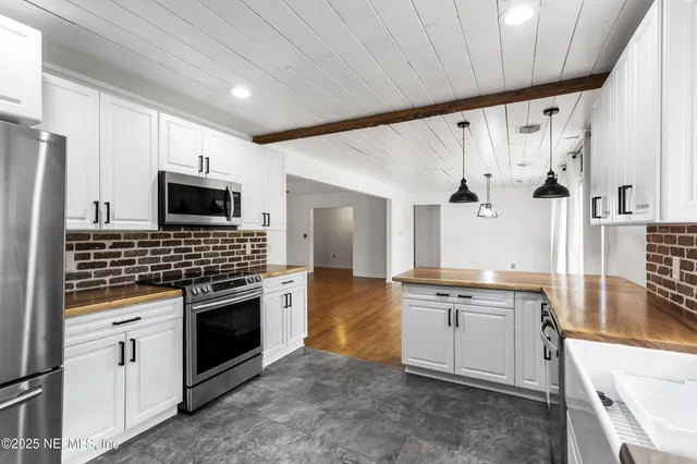 a kitchen with stainless steel appliances a stove sink and microwave