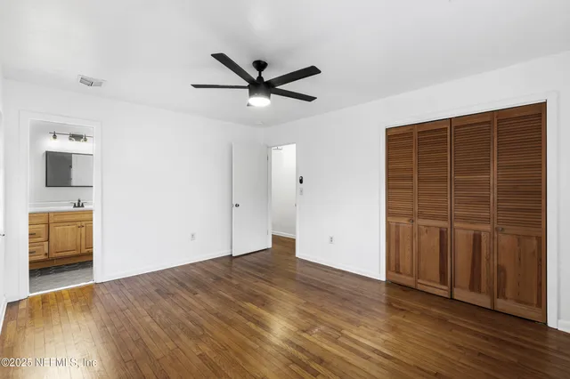 a view of empty room with wooden floor and entryway