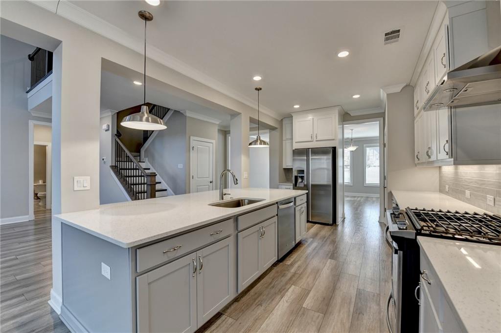 3445 Benedict Place Suwanee, GA 30024 - Photo 11 of 59 a kitchen with a stove a sink and a refrigerator