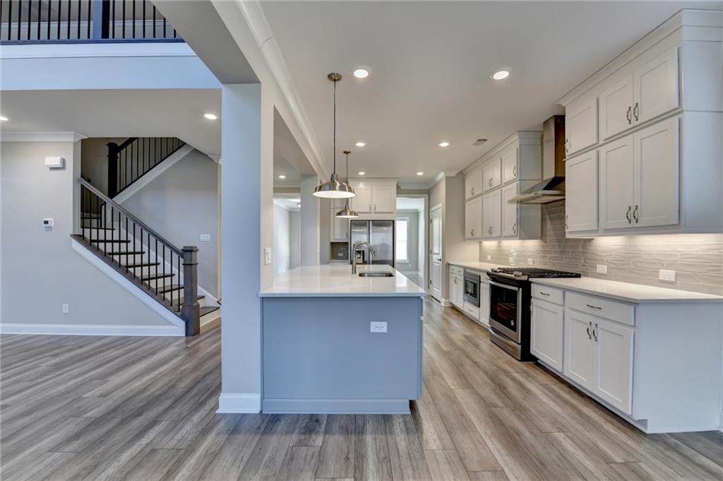 3445 Benedict Place Suwanee, GA 30024 - Photo 12 of 59 a kitchen with stainless steel appliances granite countertop a sink stove and cabinets