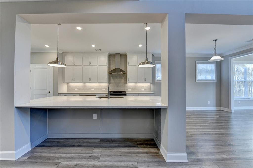 3445 Benedict Place Suwanee, GA 30024 - Photo 14 of 59 a kitchen with kitchen island a sink stainless steel appliances and cabinets