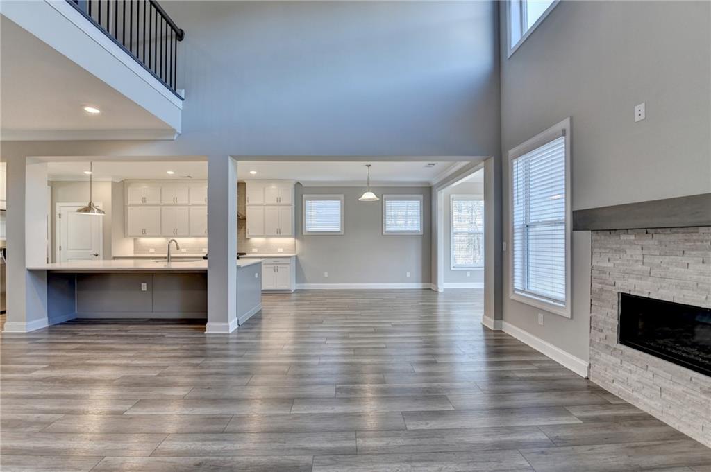 3445 Benedict Place Suwanee, GA 30024 - Photo 18 of 59 an empty room with wooden floor and a fireplace