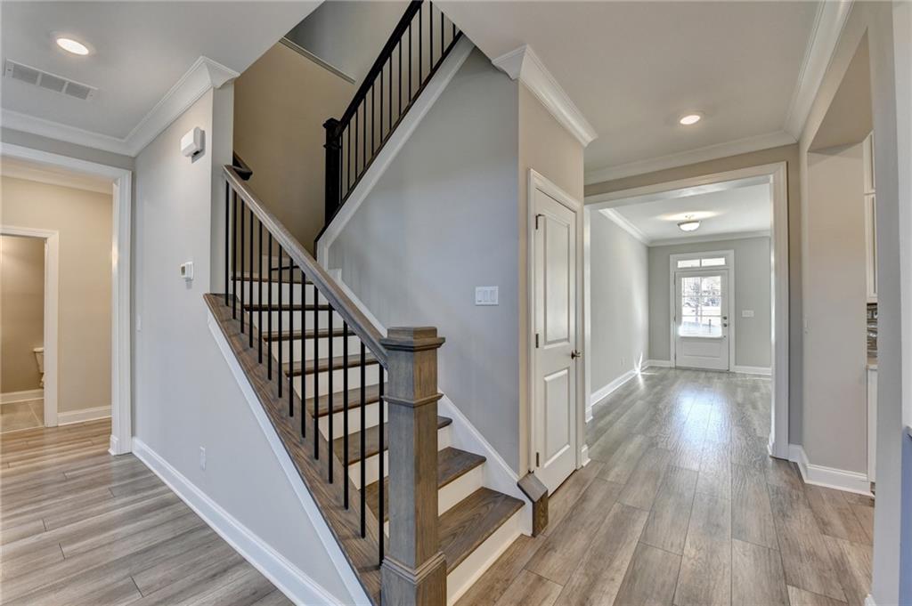 3445 Benedict Place Suwanee, GA 30024 - Photo 24 of 59 a view of a hallway with wooden floor and staircase