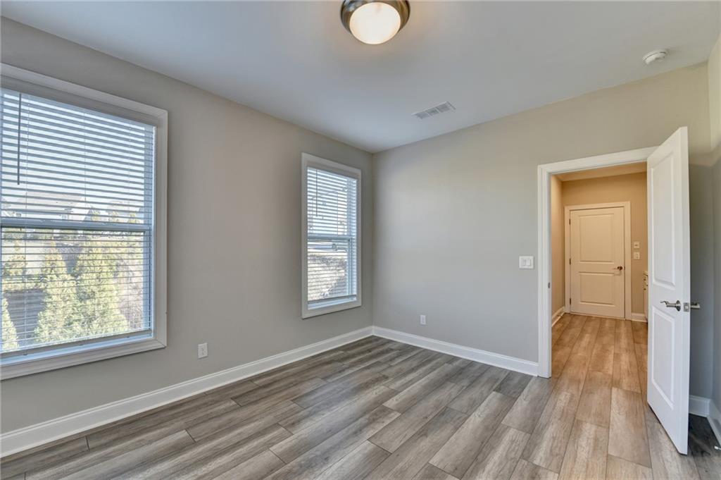 3445 Benedict Place Suwanee, GA 30024 - Photo 26 of 59 a view of an empty room with wooden floor and a window