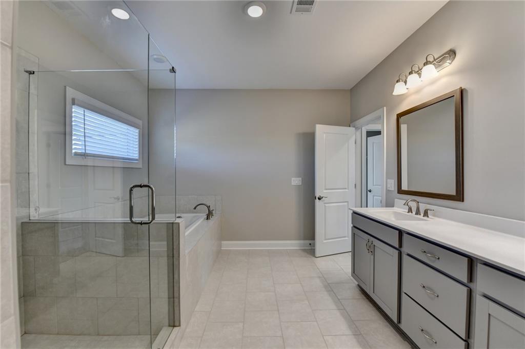 3445 Benedict Place Suwanee, GA 30024 - Photo 40 of 59 a bathroom with a double vanity sink a mirror and a shower