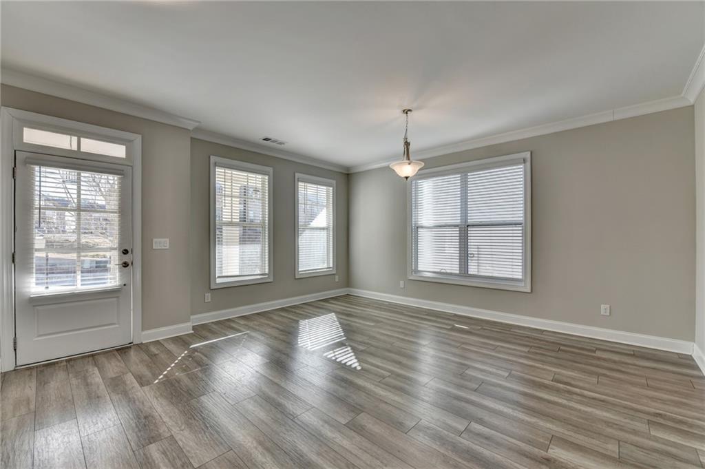3445 Benedict Place Suwanee, GA 30024 - Photo 4 of 59 an empty room with wooden floor and windows
